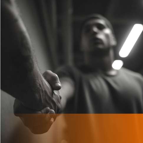 Man reaching out for a handshake in a gym setting