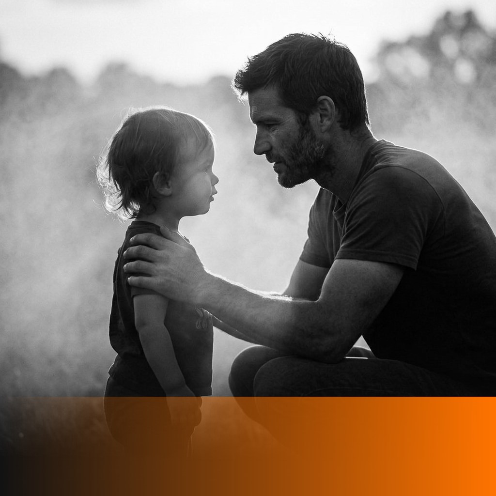 MenTools blog feature image for how to be a present dad when you work full time, black and white photograph of a father crouched at his young child's eye level in warm backlight, orange MenTools overlay band